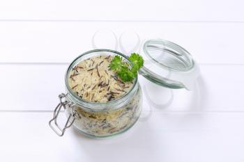 jar of wild rice on white wooden background