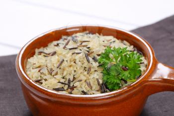 saucepan of wild rice on grey place mat - close up