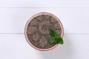 bowl of chia seeds on white wooden background