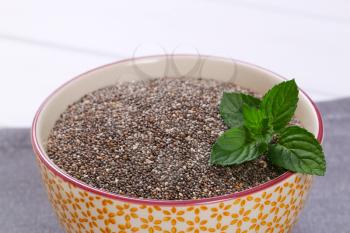 bowl of chia seeds on grey place mat - close up