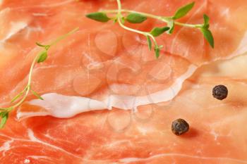 detail of air dried ham slices with thyme and pepper - full frame