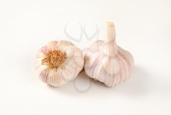 two bulbs of garlic on white background