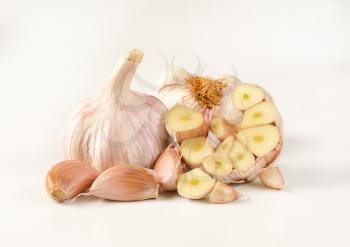 bulbs and cloves of fresh garlic on white background