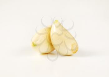 peeled cloves of fresh garlic on white background