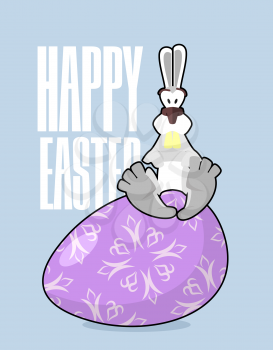 Happy Easter. Rabbit and Easter egg. Traditional treats for Easter. Colored eggs. Funny Bunny sitting on  egg. Symbol of Easter holiday
