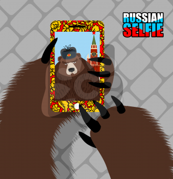 Russian bear selfie on red square. Wild bear and tower of Moscow Kremlin. Animal photography of himself. Forest animal paw presses smartphone
