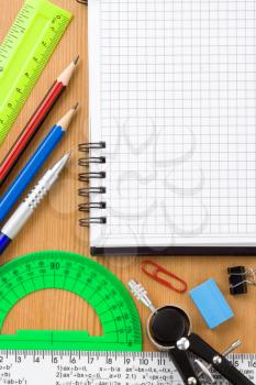 back to school and supplies near checked notebook at wood background texture