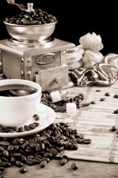 cup full of coffee, beans, pot and grinder in black and white