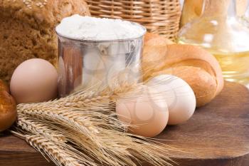 bread, oil, basket and eggs on board