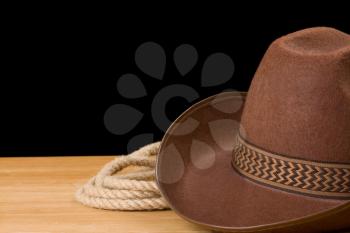 brown cowboy hat and rope isolated on black background