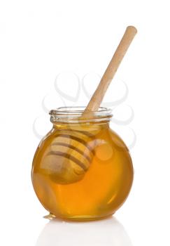 glass pot full of honey and stick isolated on white background