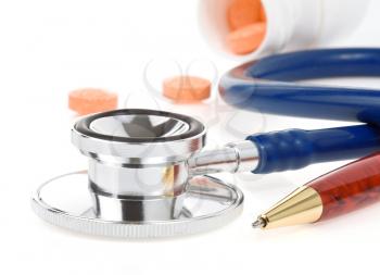 medical stethoscope with pills isolated on white background