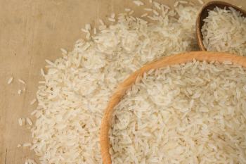 uncooked rice and wood spoon as background