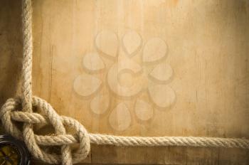 ship ropes and compass on old wood background