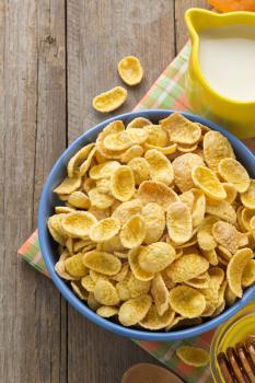 bowl of corn flakes  on wooden background