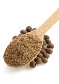 allspice powder and wooden spoon isolated on white background