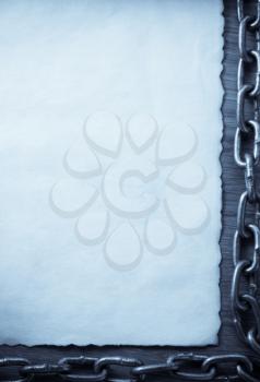 metal chain and old vintage ancient paper at wooden background