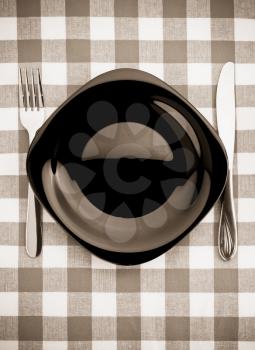 knife and fork at plate on napkin background