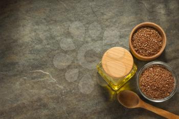 linseed oil in bottle and flax seeds on table background