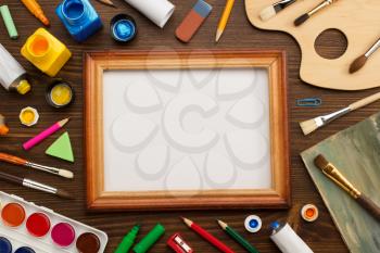 paint supplies and brush on wooden background