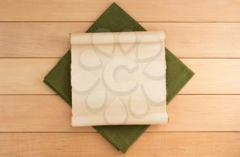 parchment and napkin on wooden background