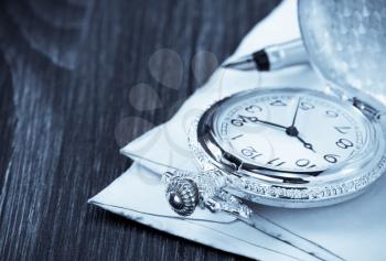 watch and old envelope on wooden background