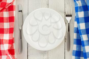 cloth napkin and plate on wooden background