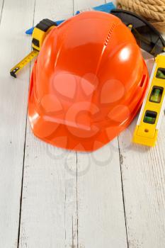 hardhat and safety glasses on wooden background