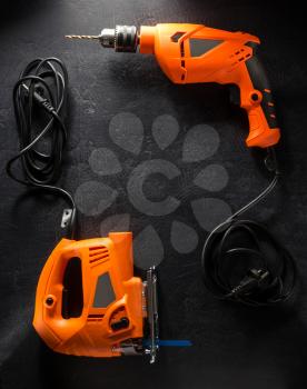 electric tools with cord on black background