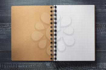 checked notebook at wooden  background texture