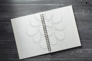 checked notebook at wooden  background texture