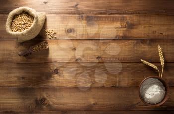 ears and wheat flour on wooden background texture