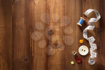 sewing tools and accessories on wooden background