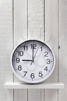 wall clock at wooden shelf background texture