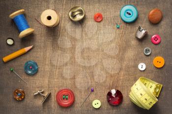 sewing tools and accessories on wooden table background