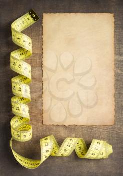 tape measure on slate stone background, top view