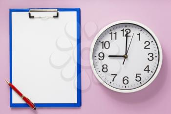 paper clipboard and wall clock at abstract background surface
