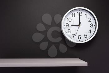 clock and shelf at wall background surface