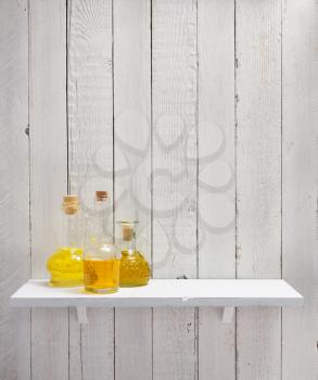 bottle of oil at shelf on wooden background