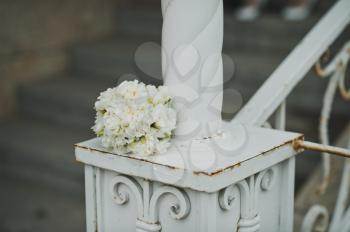Bouquet from beige roses on a shod handrail.