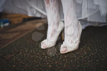 Feet of the bride in beautiful white stockings.