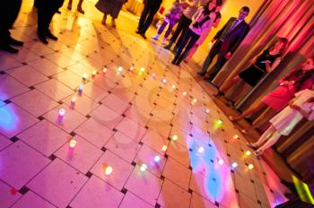 Candles are placed on a floor in the form of heart.