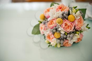 Bouquet from beige and red roses on a table.
