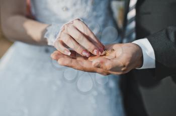 Spouses hold rings on palms.