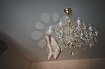 Womens shoes on a chandelier.