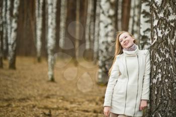The young girl costs about a tree a birch.