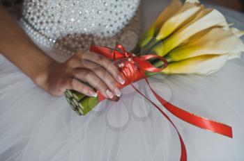 The girl holds a bouquet.