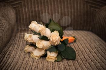 Bouquet from beige roses on a striped chair.