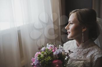 Portrait of a girl with bouquet in hand.