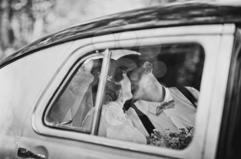 The bride and groom in the cabin of the old car.